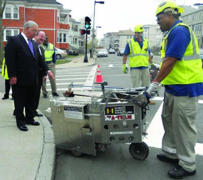 In Mattapan, 2010: The mayor's playful side came out often. Here, he's busting chops as workers paint a sidewalk. "Hey, ya missed a spot." Photo by Bill Forry